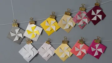 Bunte origami Windmühlen hängen an einer Schnur.