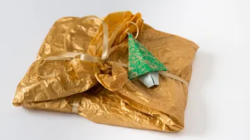 Gift wrapped in golden paper with green tree pendant