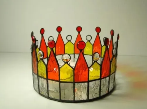 Bunte Krone aus Glas steht auf einem weißen Tisch.