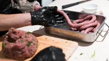 Raw meat is placed in a bowl in sausage form.