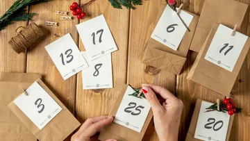 Houses decorate advent calendars on a wooden table.