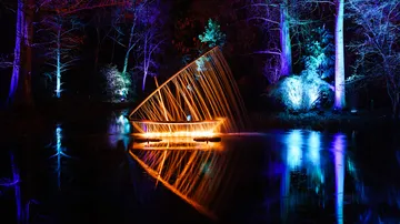 Leuchtendes Boot reflektiert in stillem, dunklem Wasser.