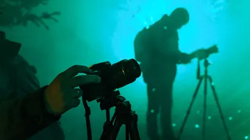Camera is held; shadow of a person in fog.