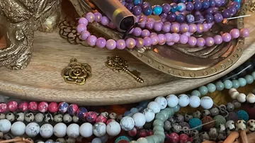 Colourful beads and figures lie on a wooden tray.