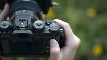 Eine Kamera wird gehalten, um Fotos in der Natur zu machen.