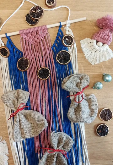 Decorative wall hanging made from strings and dried citrus fruits.