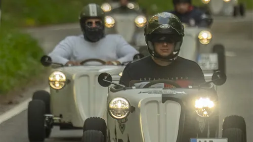 Kleine Autos fahren auf einer kurvigen Landstraße.