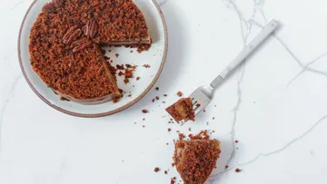 Kuchen auf Teller, Stück wird mit Gabel herausgenommen.