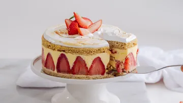 Torte mit Erdbeeren wird auf einem Tisch serviert.