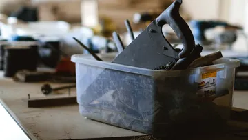 Ein Behälter mit Werkzeugen steht auf einem Tisch.