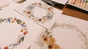 Aquarellblumenmuster liegen auf einem Tisch zum Zeichnen.