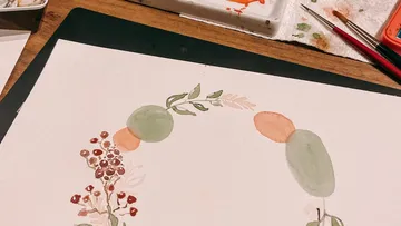 Watercolor reaction on paper, decorative plant motifs in the making.