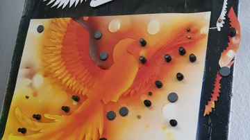 Bunte Wanddekoration mit einem Phönix, umgeben von Stiften.