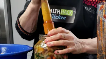 Ein Glas wird mit einem Holzstößel gestopft.