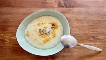 Bowl of hot soup on wooden surface