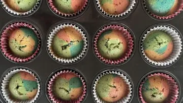 Colourful muffins in cases, fresh out of the oven.