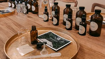 Brown bottles are placed on a table, next to materials.