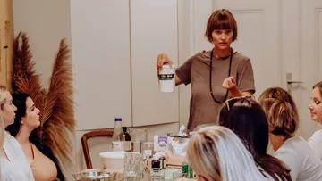 Woman presents a container in a meeting room.