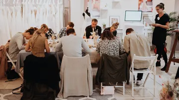 A group is sitting around a table discussing bridal fashion.