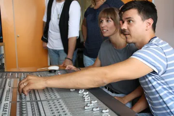A man operates a mixer in a studio.
