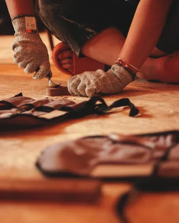 Hände mit Handschuhen reparieren etwas auf einem Boden.