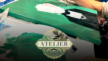 Künstler malt ein Bild in einem Atelier mit grüner Farbe.