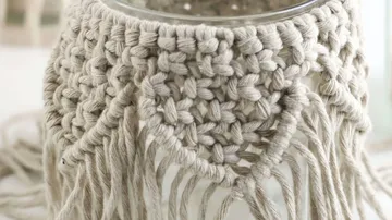 Embroidered plant containers surround a glass container in the decoration.