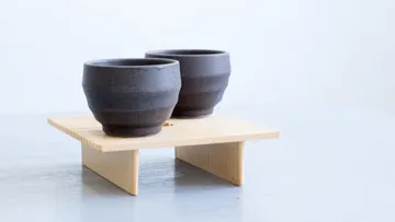 Zwei Tassen stehen auf einem Holzständer.