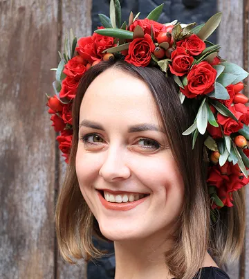 Lächelnde Frau mit roter Blumenkrone.