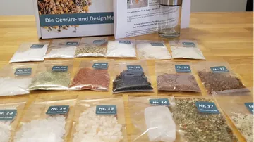 Spices arranged in transparent bags on a wooden table.