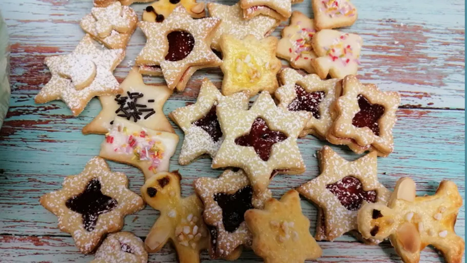 Decorated star-shaped cookies on wooden surface.