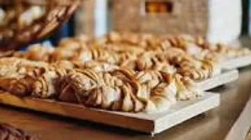 Pastries presented on a wooden board in a bakery.