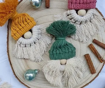 Three handmade figures with woolen hats lie on a trivet.