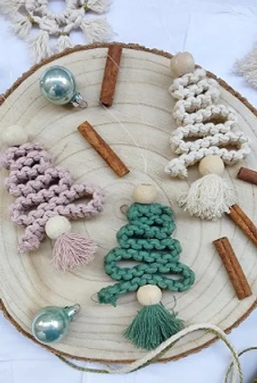 Drei gehäkelte Weihnachtsbäume auf einer Holzplatte.