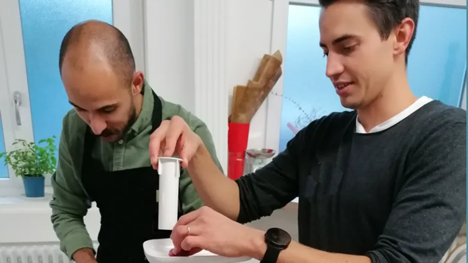 Two men cooking together in a kitchen.