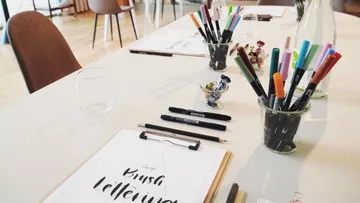Bunte Stifte liegen auf einem Tisch, bereit zum Zeichnen.