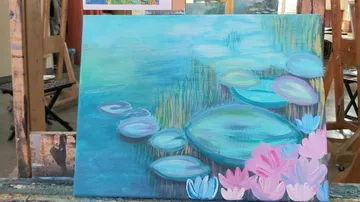 A painting depicts water lilies on a blue pond.