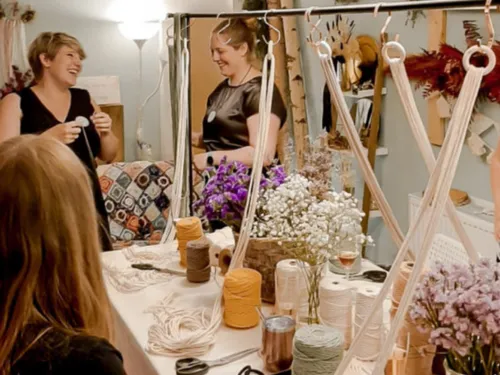 Two women laugh as they work in a creative space.