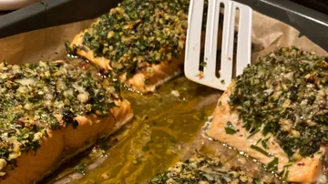 Lachsfilets mit Kräutermischung auf einem Blech, garen.