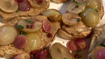 Geröstetes Brot mit Trauben und Chives als Belag.