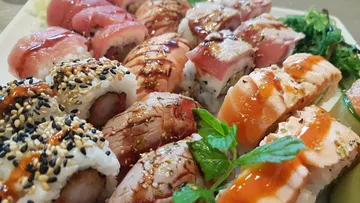 Sushirollen liegen auf einem Teller, dekorativ angerichtet.