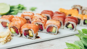 Sushi-Rollen liegen auf einem weißen Teller, frisch angerichtet.