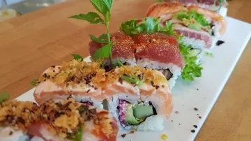 Buntes Sushi auf einem weißen Teller, frische Zutaten sichtbar.