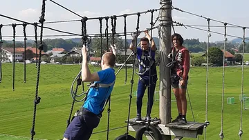 Three people on an adventure cable car in nature.