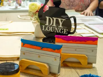 Bunte Schablonen liegen auf einem Tisch im DIY-Bereich.