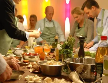 Cooking utensils are used around a table in a cooking group.