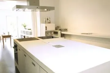 Modern kitchen counter with hob in a bright, minimalistic room.
