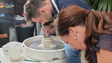 Pottery: People form clay on a turntable in a studio-like environment.