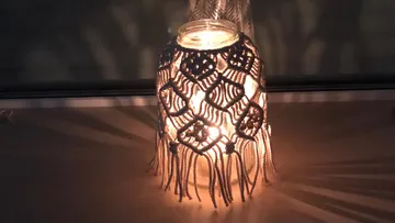 Decorative lamp glows, creates shadow patterns on the table.