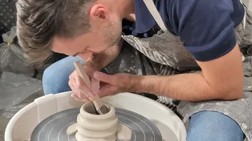 Töpfer dreht Keramik, um Gestaltung zu verfeinern.